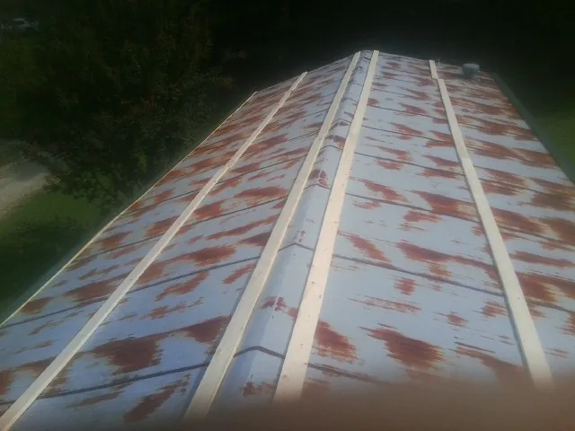 Rusted metal roof panels with new wood purlins before replacement — Storm Damage Roof Repair in Smithton by Roofing Brothers