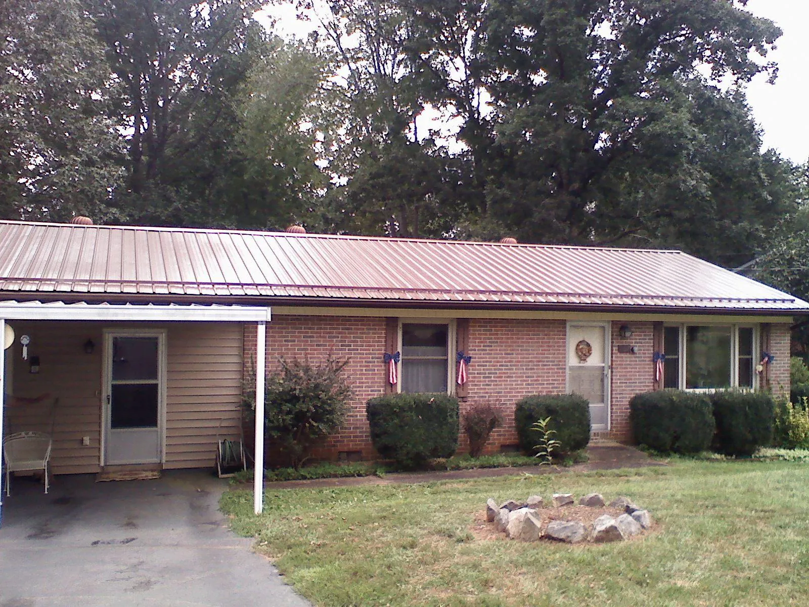 Bronze metal roof and carport on a brick ranch home — Roof Repair work by our crew in Smithton